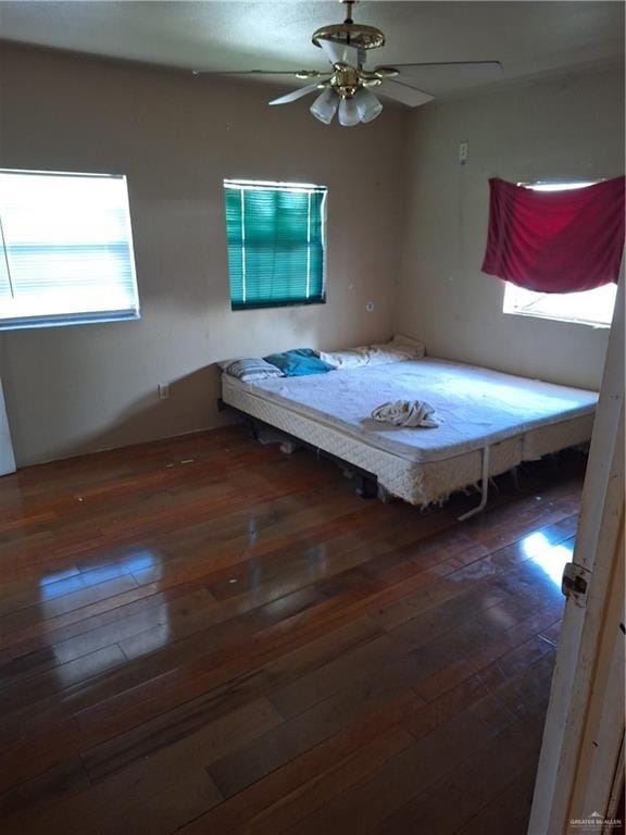 unfurnished bedroom with ceiling fan and dark hardwood / wood-style flooring