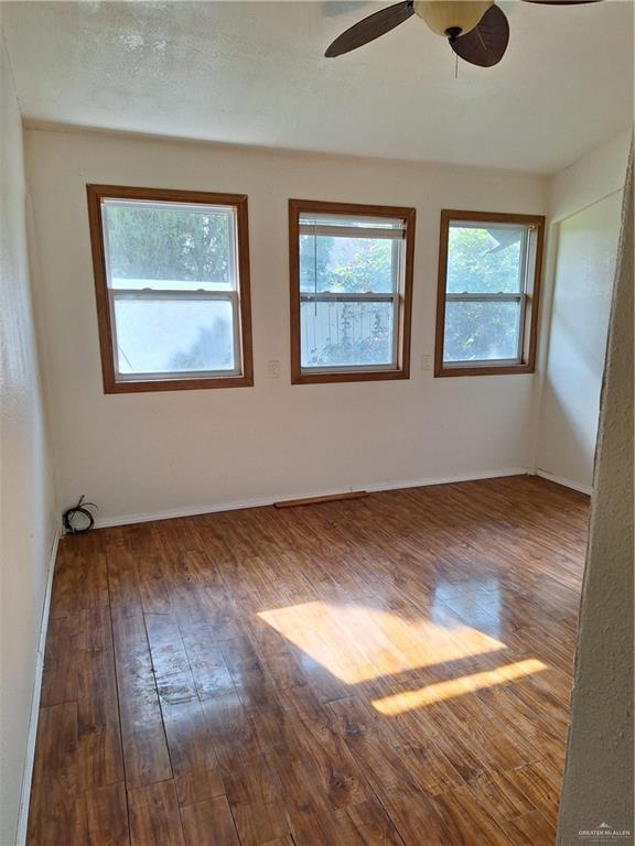 unfurnished room with ceiling fan and wood-type flooring