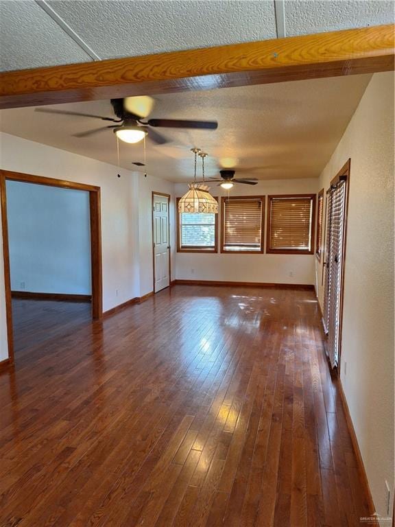 unfurnished living room with ceiling fan, dark wood-type flooring, and a textured ceiling