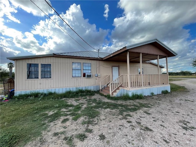 manufactured / mobile home featuring cooling unit, metal roof, and driveway