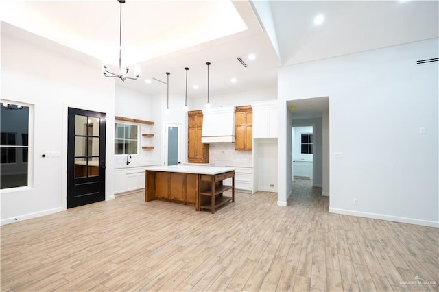 kitchen featuring white cabinetry, a kitchen island, and light wood-type flooring