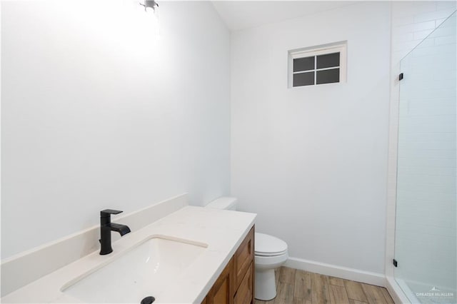 bathroom featuring hardwood / wood-style floors, vanity, an enclosed shower, and toilet