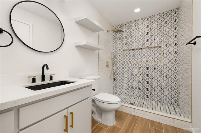 bathroom featuring toilet, recessed lighting, vanity, wood tiled floor, and a stall shower