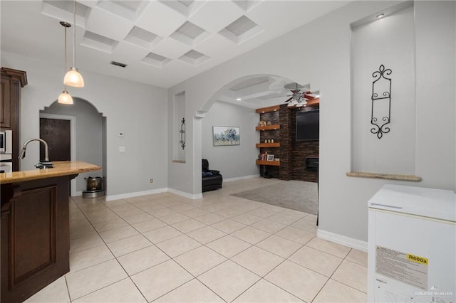 kitchen with dark brown cabinetry, ceiling fan, sink, hanging light fixtures, and light tile patterned flooring