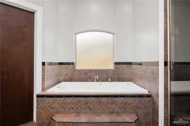 bathroom with a relaxing tiled tub