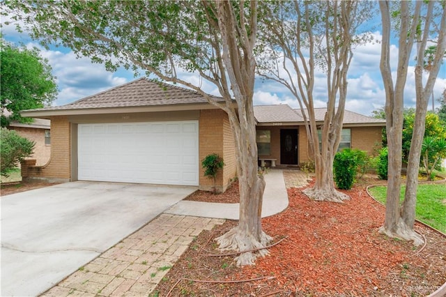 single story home featuring driveway, a shingled roof, an attached garage, and brick siding
