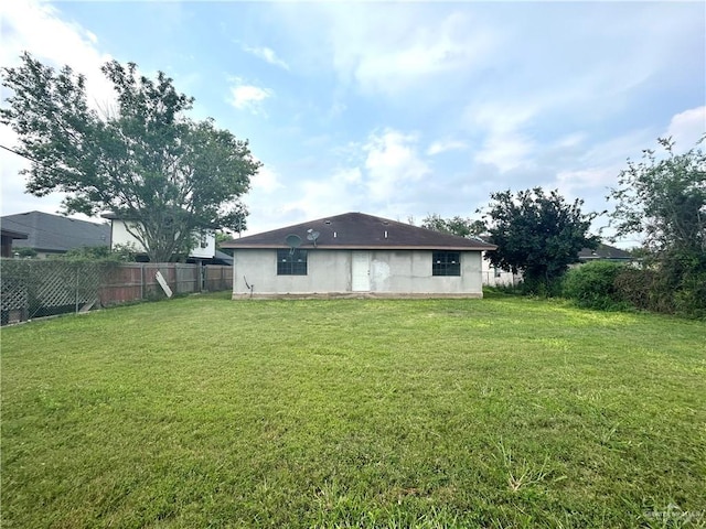 rear view of house featuring a lawn