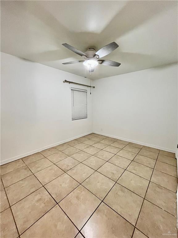 tiled empty room with ceiling fan