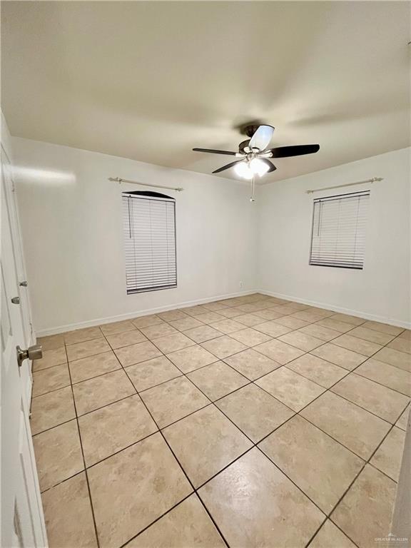 empty room featuring ceiling fan and light tile patterned floors