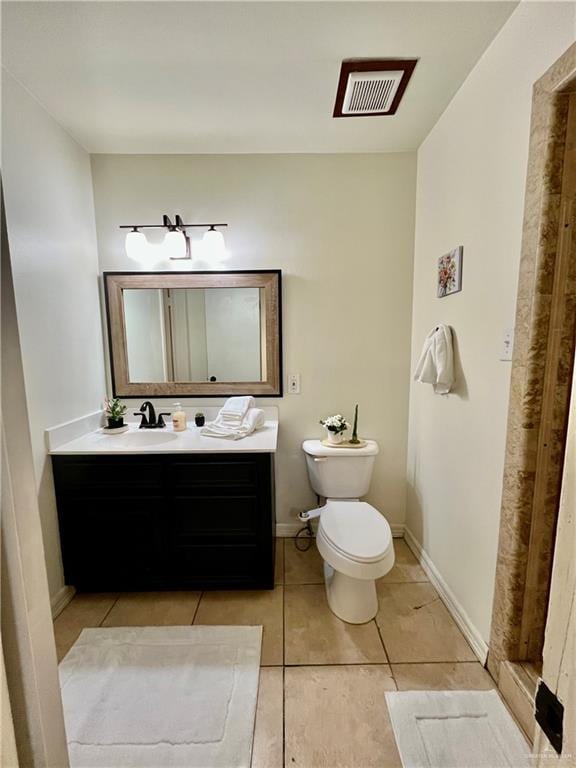 bathroom featuring toilet, vanity, and tile patterned floors