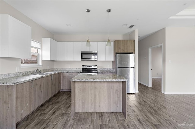 912 Kentucky St, Alton, TX 78573 - kitchen with stainless steel appliances, a kitchen island, a sink, and wood finished floors
