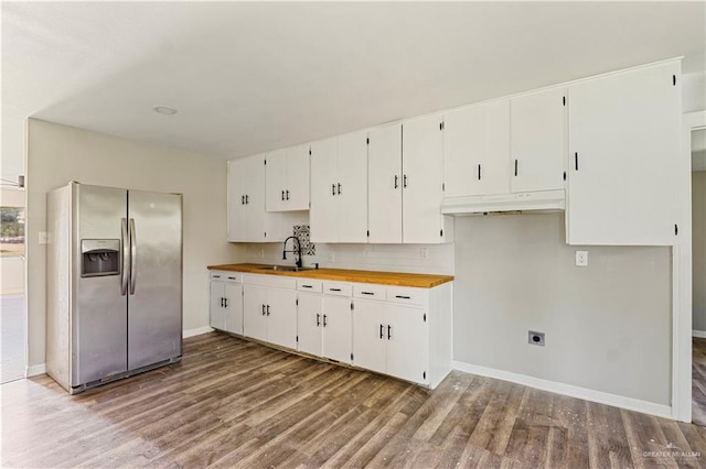 1125 W Schunior St, Edinburg, TX 78541 - kitchen with stainless steel fridge with ice dispenser, wood finished floors, wooden counters, white cabinets, and under cabinet range hood