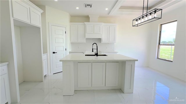 kitchen with white cabinets, sink, and a kitchen island with sink