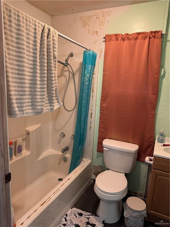 full bathroom featuring toilet, shower / bath combo, and vanity