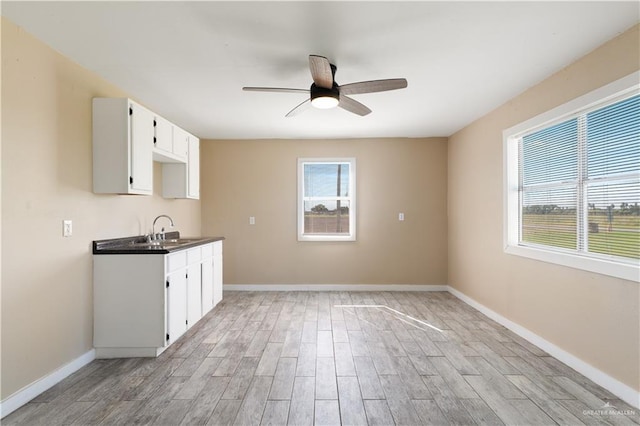 kitchen with ceiling fan, sink, white cabinets, and light hardwood / wood-style floors