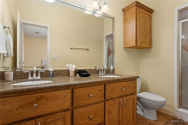 bathroom featuring toilet, vanity, tile patterned floors, and an enclosed shower