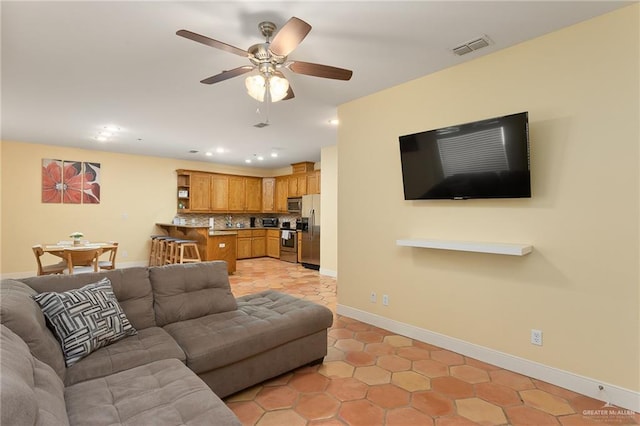 tiled living room with ceiling fan