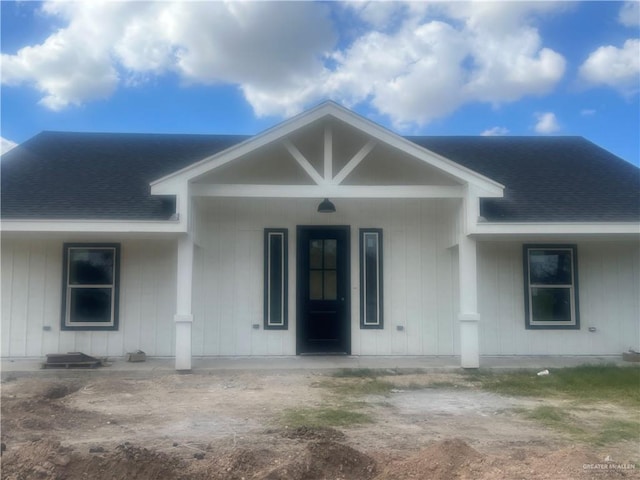 view of front of house with covered porch and a shingled roof