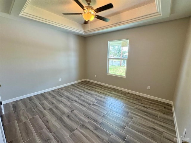 209 S Raul Longoria Rd, Edinburg, TX 78542 - empty room with a raised ceiling, ceiling fan, baseboards, and wood finish floors