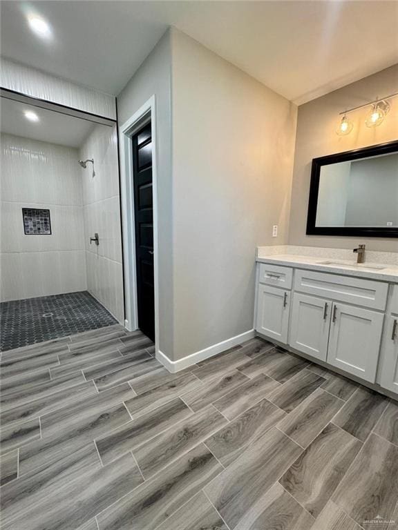 209 S Raul Longoria Rd, Edinburg, TX 78542 - full bath with a tile shower, wood finish floors, vanity, and baseboards