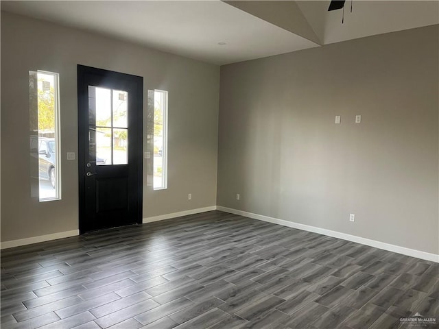 entrance foyer with a ceiling fan, baseboards, and dark wood-type flooring