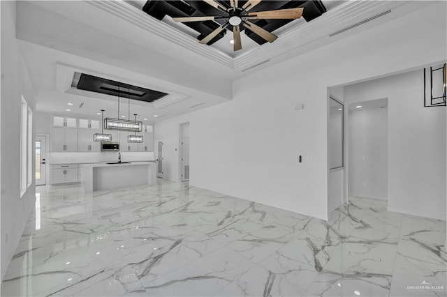 unfurnished living room featuring marble finish floor, visible vents, a raised ceiling, and crown molding