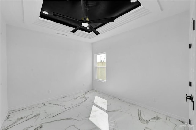 unfurnished room with crown molding, marble finish floor, a tray ceiling, and baseboards