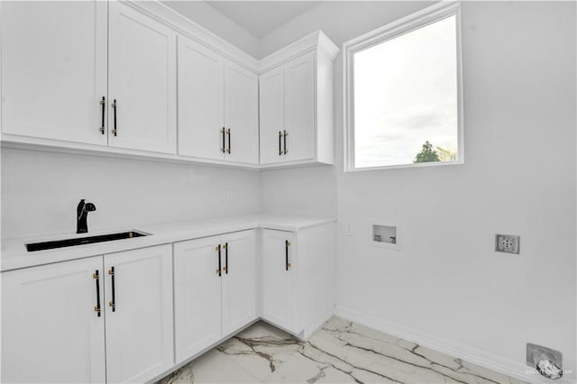 clothes washing area with washer hookup, a sink, baseboards, marble finish floor, and cabinet space