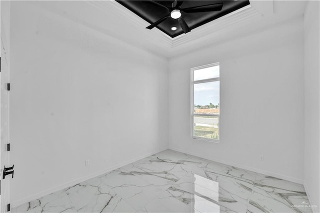 empty room featuring a tray ceiling, marble finish floor, ceiling fan, and baseboards