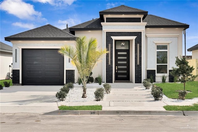 view of front of property featuring a garage, concrete driveway, and stucco siding