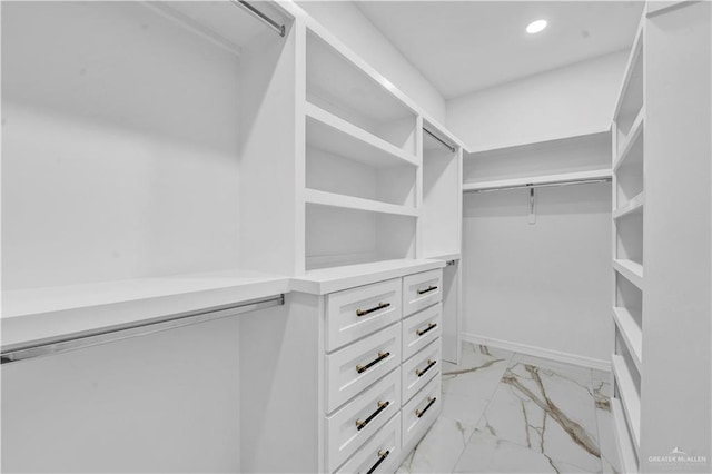 walk in closet featuring marble finish floor