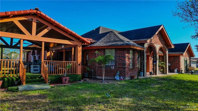 rear view of house featuring a lawn