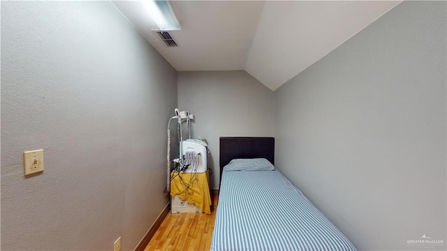 bedroom with hardwood / wood-style floors and vaulted ceiling