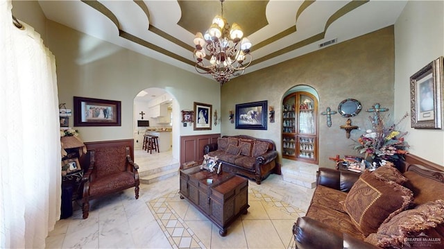 living room featuring a towering ceiling and an inviting chandelier