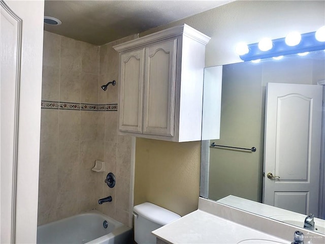 full bathroom featuring vanity, toilet, and tiled shower / bath