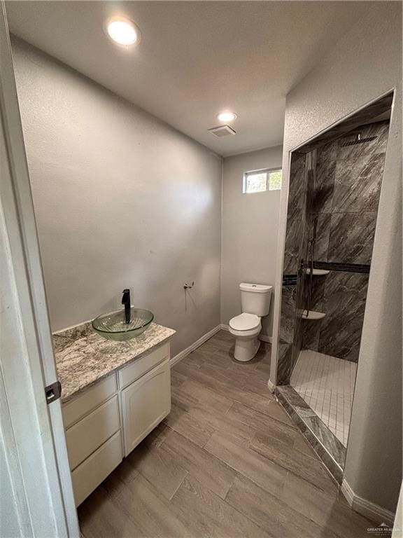 1012 S Inspiration Rd, Mission, TX 78573 - bathroom with toilet, walk in shower, vanity, baseboards, and wood finished floors