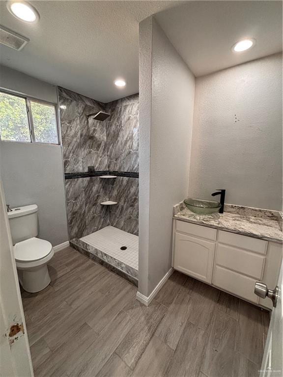 1012 S Inspiration Rd, Mission, TX 78573 - full bathroom with tiled shower, toilet, vanity, wood finished floors, and recessed lighting