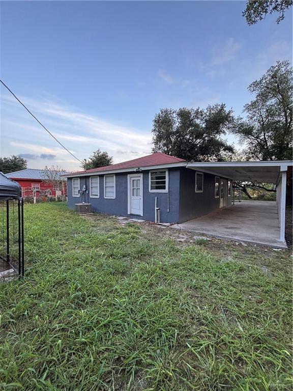 1012 S Inspiration Rd, Mission, TX 78573 - view of front facade with stucco siding, a carport, and a front lawn