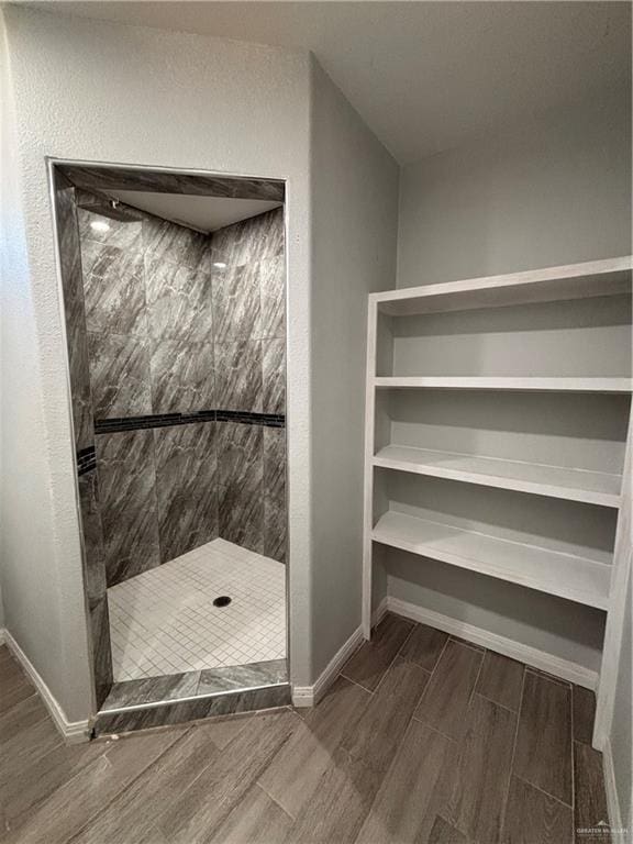 1012 S Inspiration Rd, Mission, TX 78573 - full bathroom featuring wood finished floors, a tile shower, and baseboards
