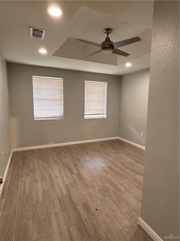1012 S Inspiration Rd, Mission, TX 78573 - spare room with ceiling fan, wood finished floors, baseboards, a tray ceiling, and recessed lighting