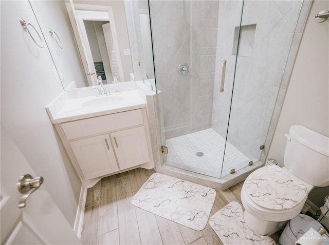 bathroom featuring vanity, hardwood / wood-style flooring, toilet, and walk in shower