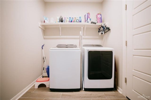 clothes washing area featuring washer and clothes dryer and wood-type flooring