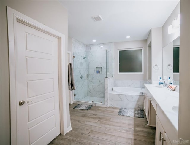 bathroom featuring vanity, wood-type flooring, and shower with separate bathtub