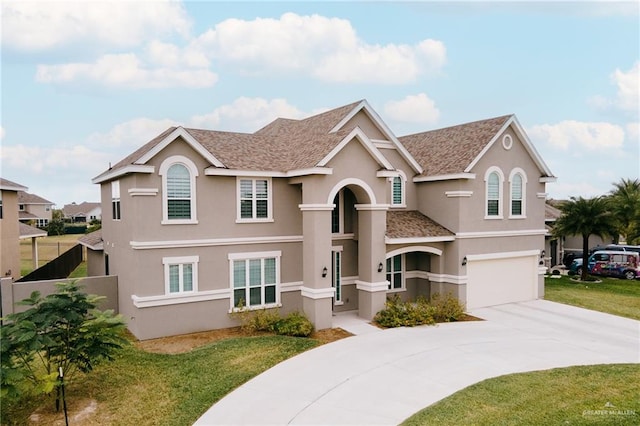 view of property with a garage and a front lawn