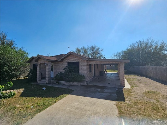 ranch-style house featuring a front yard and a carport