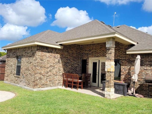 rear view of house with a yard and a patio