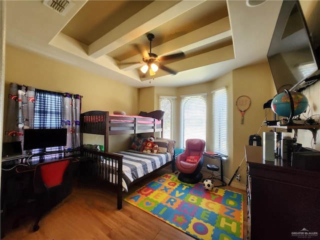 bedroom with a tray ceiling, ceiling fan, beamed ceiling, and hardwood / wood-style flooring