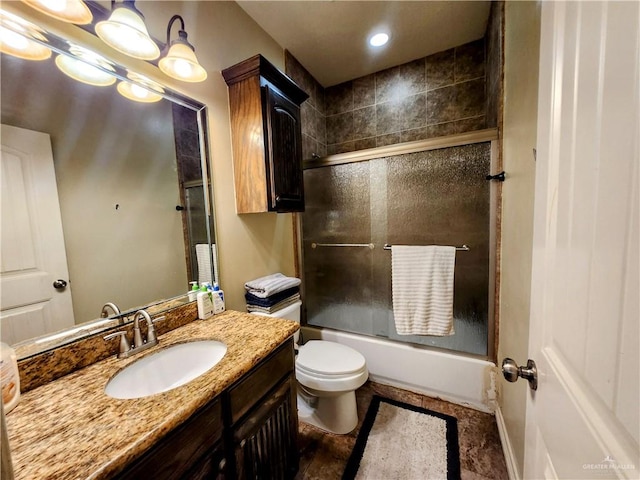 full bathroom featuring combined bath / shower with glass door, vanity, and toilet