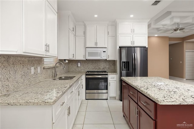 kitchen featuring appliances with stainless steel finishes, a sink, white cabinetry, decorative backsplash, and visible vents