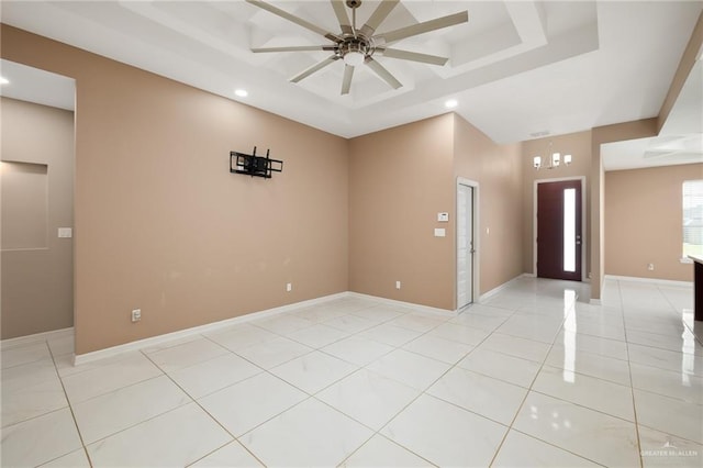empty room with light tile patterned floors, a raised ceiling, a ceiling fan, and recessed lighting